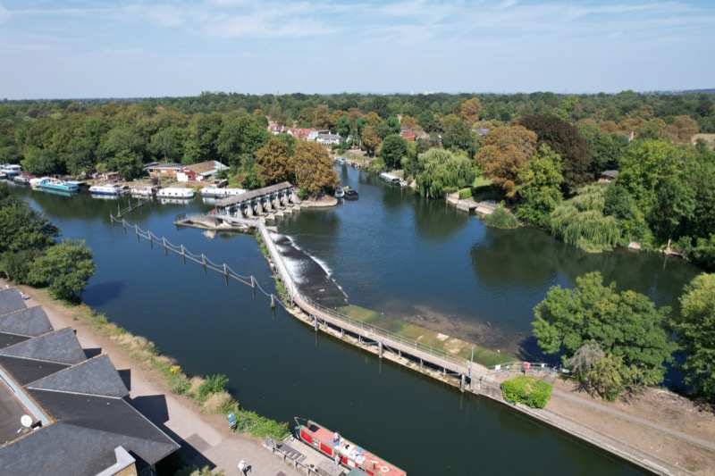 Wide aerial shot showing river, weir and surrounding greenery