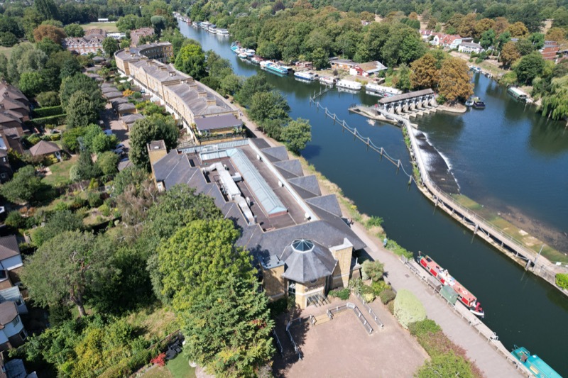 Aerial view of riverside property showing full grounds, river and surrounding area