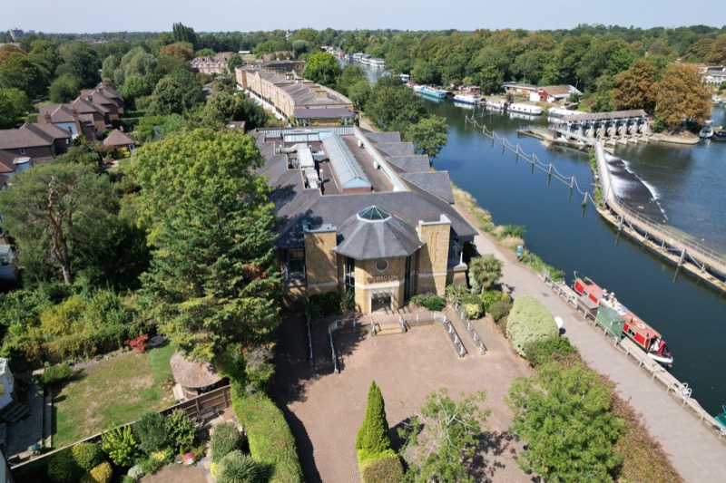 Drone photograph of property frontage with gardens and river behind