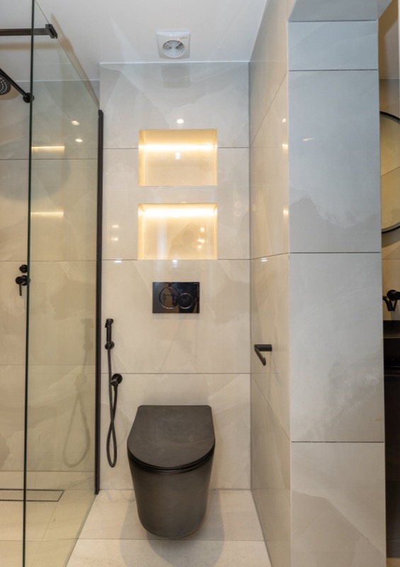 Modern bathroom with lit niches and black fittings