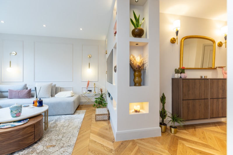 Bright living space with decorative room divider and warm wood floors