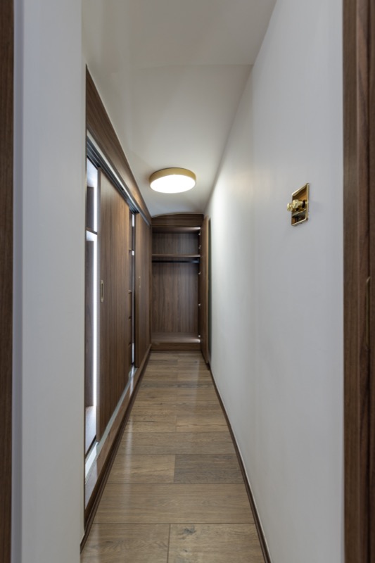 Walk-in wardrobe corridor with walnut joinery