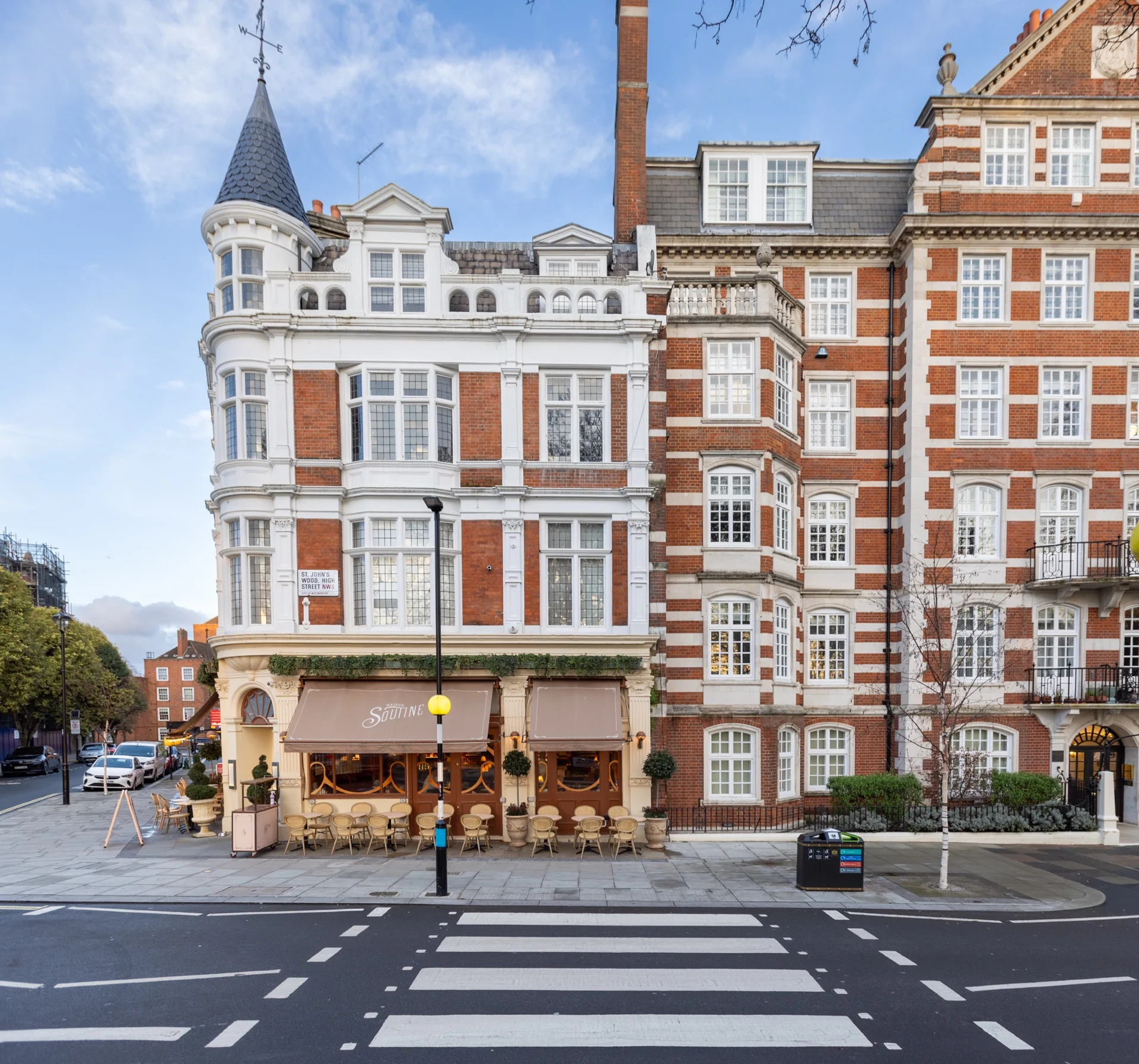 Corner mansion block building with distinctive turret and café at street level in NW8