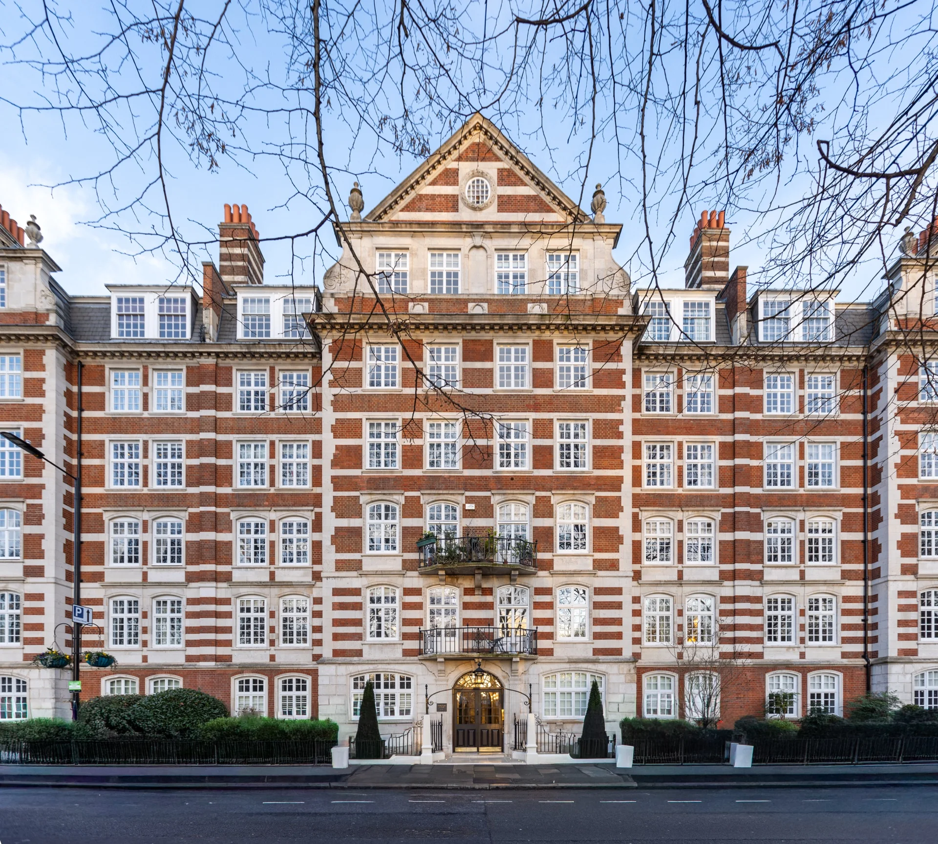 Symmetrical red brick mansion block with grand arched entrance in St John's Wood NW8